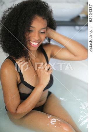 Portrait of black girl taking bath and wearing swimsuit. Portrait of black girl taking bath and wearing swimsuit. 62664327