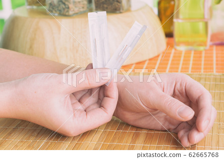 Hand applying acupuncture needle 62665768