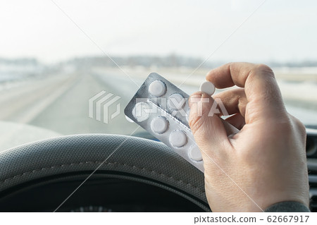 View of the driver hand holding a bag of pills 62667917