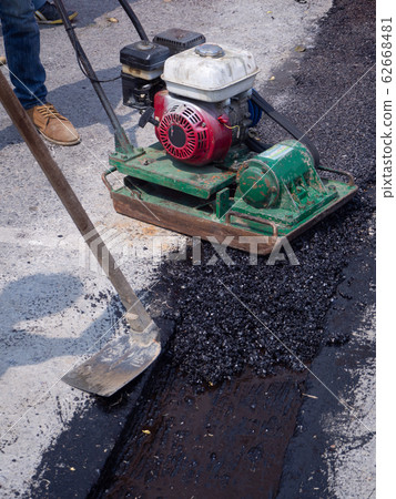 Worker use vibratory plate compactor compacting 62668481