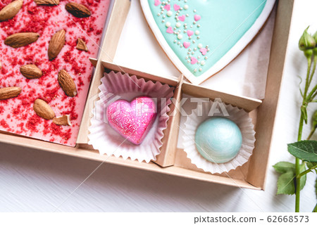 Gift set with hand made sweets in a box on a white table. Gift set with hand made sweets in a box on a white table. 62668573