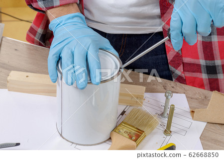 house painter opens a can of paint with a 62668850