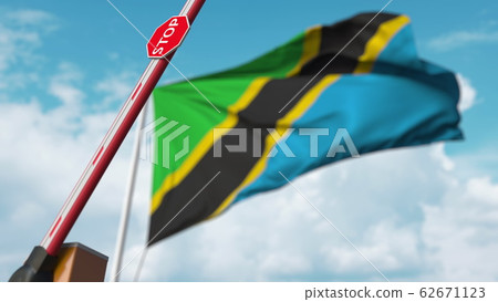 Opening boom barrier with stop sign against the Tanzanian flag. Free border crossing or lifting a ban in Tanzania. 3D rendering Opening boom barrier with stop sign against the Tanzanian flag. Free border crossing or lifting a ban in Tanzania. 3D rendering 62671123