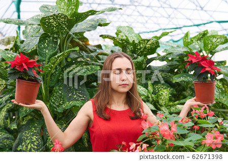 young woman with closed eyes in a red dress in a young woman with closed eyes in a red dress in a 62671398