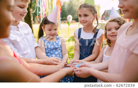 Children playing outdoors on birthday party in garden in summer. Children playing outdoors on birthday party in garden in summer. 62672839