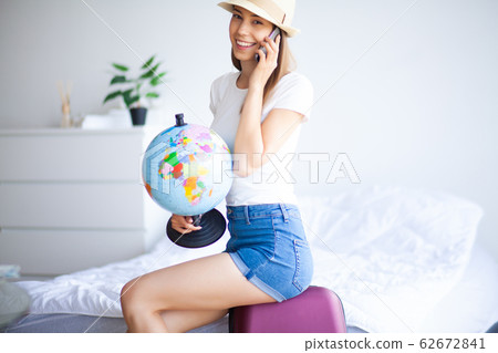 Beautiful girl sitting on the bed and goes on vacation Beautiful girl sitting on the bed and goes on vacation 62672841