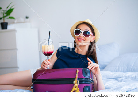 Beautiful girl sitting on the bed and goes on vacation 62672880