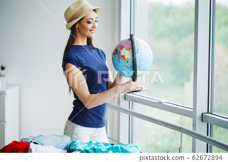 Beautiful woman collects clothes in travel suitcase on a trip 62672894