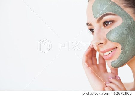 Beautiful young woman with cosmetic spa facial mask 62672906