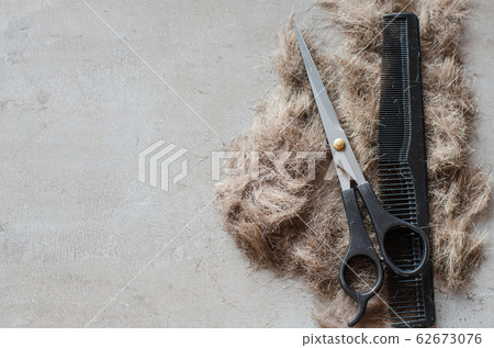 Pile of cut hair, scissors for haircuts and comb. Tools for haircuts. Pile of cut hair, scissors for haircuts and comb. Tools for haircuts. 62673076