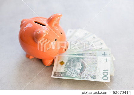 Piggy bank with polish money on concrete table - saving profit concept in horizontal banner 62673414