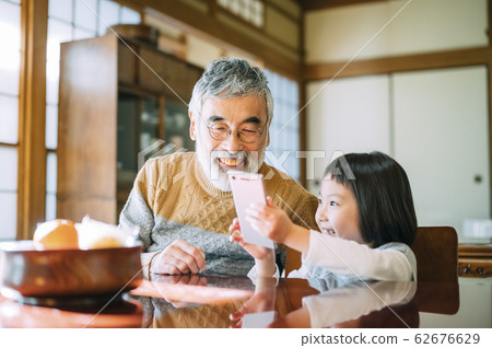Grandpa and grandson using smartphone Grandpa and grandson using smartphone 62676629