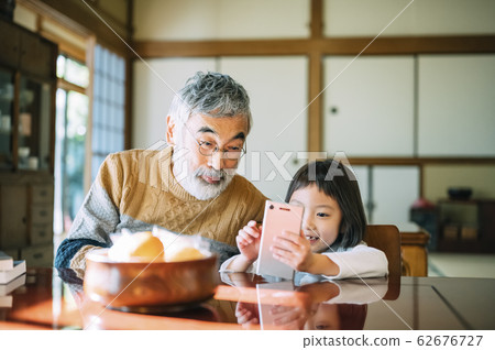 Grandpa and grandson using smartphone 62676727