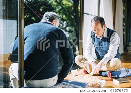 Senior man playing shogi 62676775
