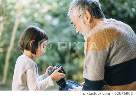 Grandpa and grandson using camera 62676908