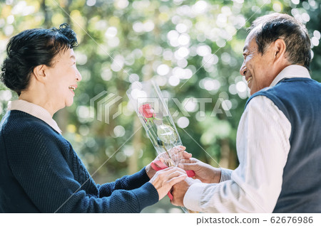 年長的夫婦獻花 62676986