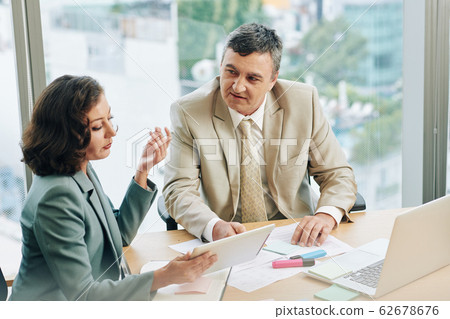 Business people discussing report Business people discussing report 62678676