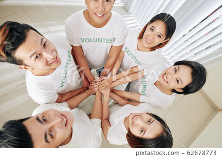 Volunteers stacking hands Volunteers stacking hands 62678773