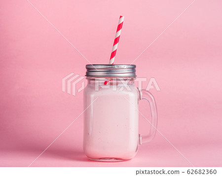 strawberry smoothie in mason jar glass on pink 62682360