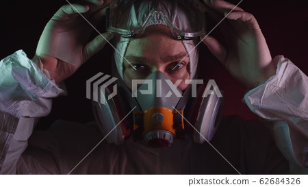 Man in protective costume suit, gas protect medical spray paint mask. Doctor in respirator. Concept health virus coronavirus epidemic. 62684326