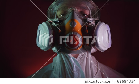 Man in protective costume suit, gas protect medical spray paint mask. Doctor in respirator. Concept health virus coronavirus epidemic. 62684334