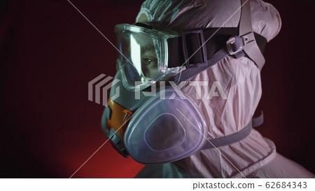 Man in protective costume suit, gas protect medical spray paint mask. Doctor in respirator. Concept health virus coronavirus epidemic. Man in protective costume suit, gas protect medical spray paint mask. Doctor in respirator. Concept health virus coronavirus epidemic. 62684343