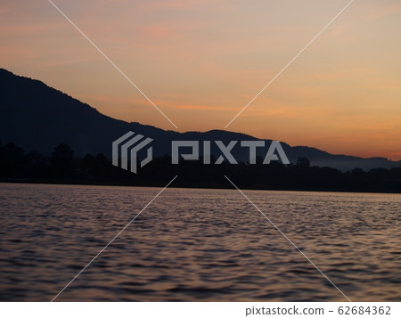 seascape scene of MEKONG river in LAOS under beautiful evening sunlight with hills silhouette in background plenty of copy space for natural adventure vacation tour advertisement 62684362