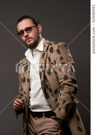 Serious male in sunglasses in jacket on brown background 62686081