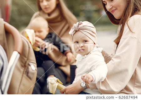 Two mothers with little children spend time in a park Two mothers with little children spend time in a park 62687494