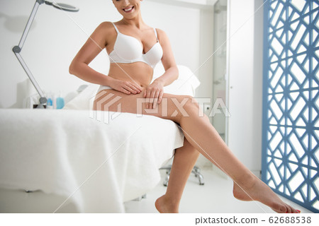 Young slender lady on couch in white underwear 62688538