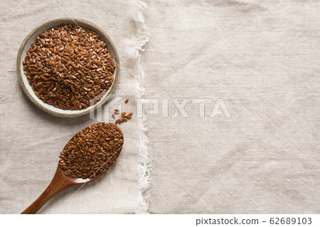 Flax seeds in wooden spoon on linen tablecloth Flax seeds in wooden spoon on linen tablecloth 62689103