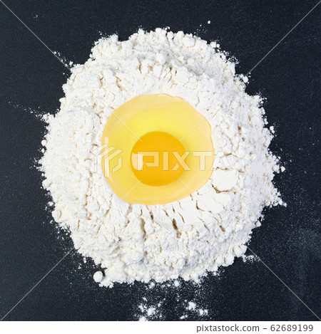 Rolling pin and white flour on a dark background 62689199