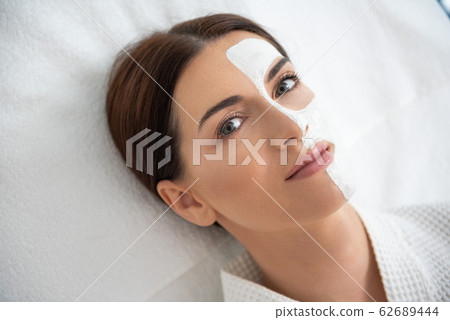 Pretty lady resting on couch with face mask Pretty lady resting on couch with face mask 62689444
