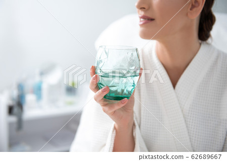 Young female with glass of water in spa center 62689667