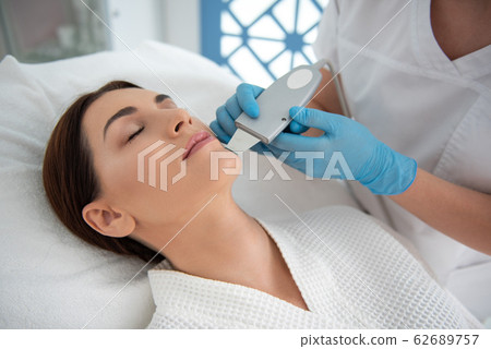 Lady enjoying of suprasonic procedure of face Lady enjoying of suprasonic procedure of face 62689757