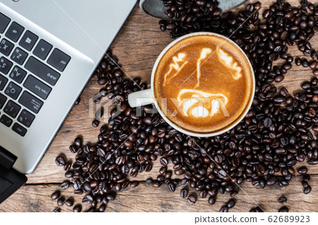 Latte art coffee cup and coffee bean with laptop 62689923