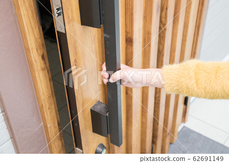 Children's hand opening a single-family entrance door 62691149