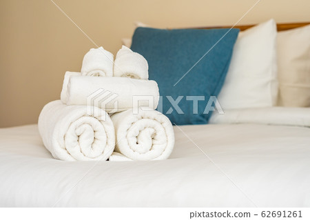 White clean bath towel on bed decoration interior White clean bath towel on bed decoration interior 62691261