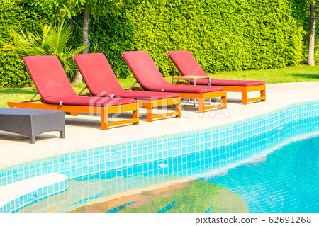Beautiful empty chair around outdoor swimming pool in hotel resort Beautiful empty chair around outdoor swimming pool in hotel resort 62691268
