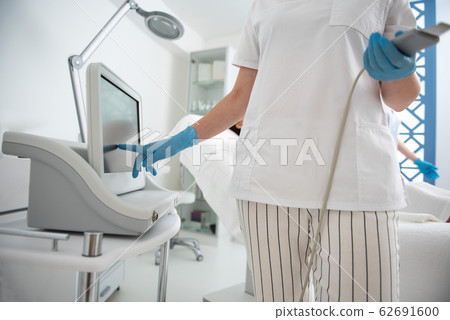 Close up lady therapist adjust suprasonic device Close up lady therapist adjust suprasonic device 62691600