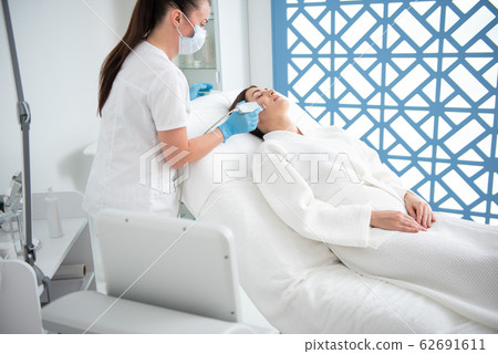 Female on suprasonic procedure of face care Female on suprasonic procedure of face care 62691611