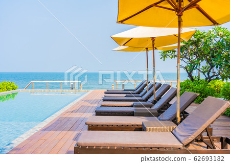 Beautiful empty chair umbrella around outdoor swimming pool in hotel resort for travel Beautiful empty chair umbrella around outdoor swimming pool in hotel resort for travel 62693182