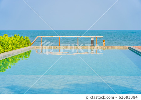 Beautiful empty chair umbrella around outdoor swimming pool in hotel resort for travel Beautiful empty chair umbrella around outdoor swimming pool in hotel resort for travel 62693384