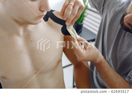 Doctor glues a tepee to an athlete at the hospital Doctor glues a tepee to an athlete at the hospital 62693817