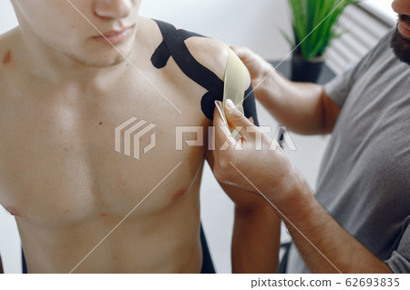 Doctor glues a tepee to an athlete at the hospital Doctor glues a tepee to an athlete at the hospital 62693835