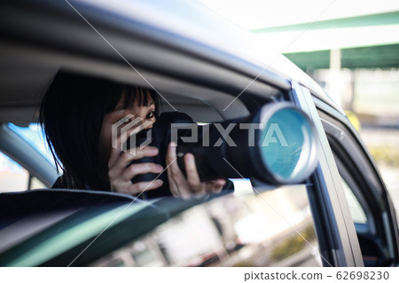 Woman taking pictures from inside the car Woman taking pictures from inside the car 62698230