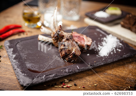 Grilled lamb chops served with a branch of rosemary 62698353