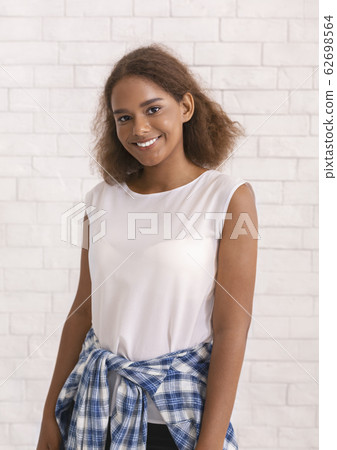 Portrait of smiling young girl over white brick wall Portrait of smiling young girl over white brick wall 62698564