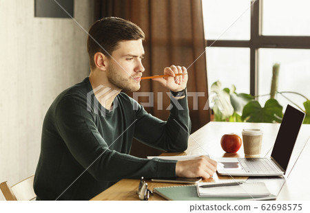 Pensive Guy Thinking On Business Idea Sitting At Desk Indoor 62698575
