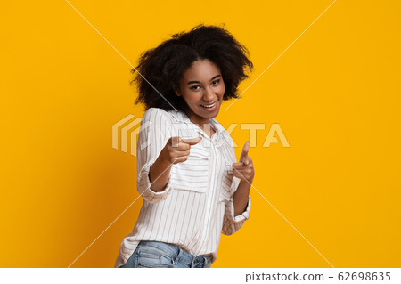 Gotcha. Positive african american woman pointing her index fingers at camera 62698635